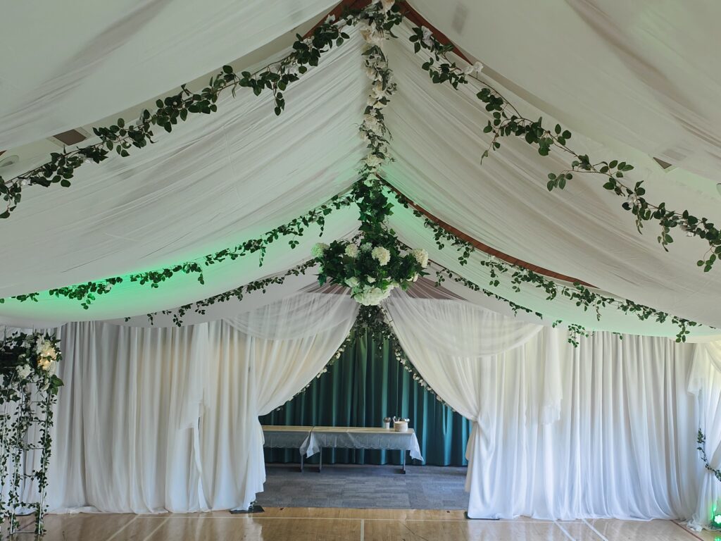 Green ivy and roses wedding with white draping