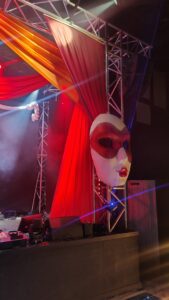 Mask prop on stage with drapes, masquerade circus theme