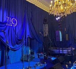 Blue wall drapes installed behind a stage for a live event {{brizy_dc_image_alt imageSrc=