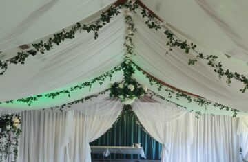 Green ivy and roses woodland wedding with white draping